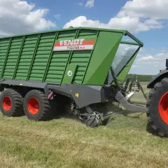 Zielona przyczepa Fendt Tigo 60 PR D, maszyna rolnicza, której kraj pochodzenia to Niemcy, pracuje na polu.