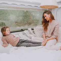 Mama i córka odpoczywają w przytulnym kamperze. Czy w kamperze można spać podczas jazdy? To pytanie zadaje sobie wielu podróżujących.