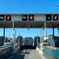 Francuskie winiety na autostradzie. Znaki informują o pasach do płatności, ograniczeniu prędkości do 30 km/h i kierunku jazdy.