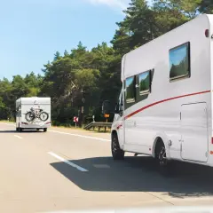 Dwa kampery jadą autostradą w Polsce. Na jednym z nich zamontowany jest bagażnik na rowery.