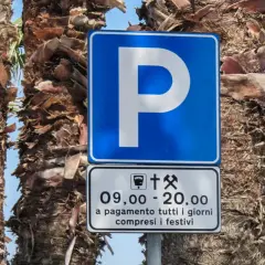 Znaki drogowe we Włoszech: niebieski znak "P" z informacją o płatnym parkingu od 9:00 do 20:00, codziennie, w tym święta.