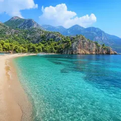 Piękna plaża z turkusową wodą i górami w tle. Idealne miejsce na podróż kamperem po Turcji.
