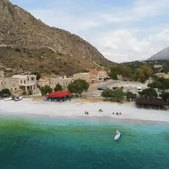 Malownicza zatoka z kamienistą plażą, domkami i tawerną. Idealne miejsce na wakacje kamperem w Grecji.