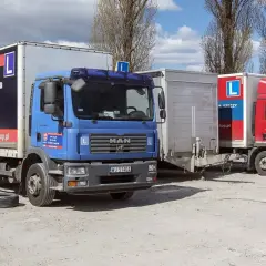 Czy mając prawo jazdy kategorii C można jeździć samochodem osobowym? Na zdjęciu ciężarówki szkoleniowe z literą L, sugerujące naukę jazdy.