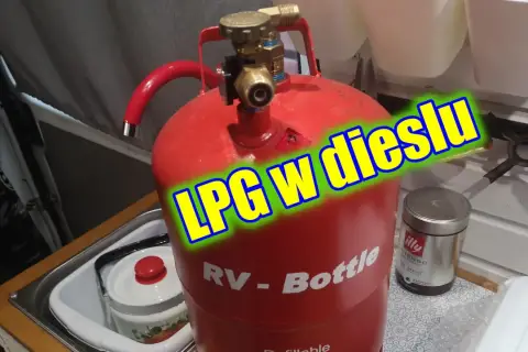 Czerwona butla gazowa RV-Bottle z zaworem, gotowa do tankowania LPG w dieslu. Obok puszka kawy Illy.