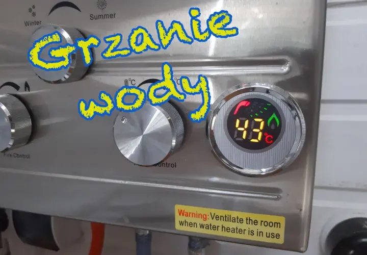 Grzanie wody w przyczepie kempingowej. Cyfrowy wyświetlacz pokazuje 43°C. Pokrętła do regulacji temperatury i kontroli ognia.