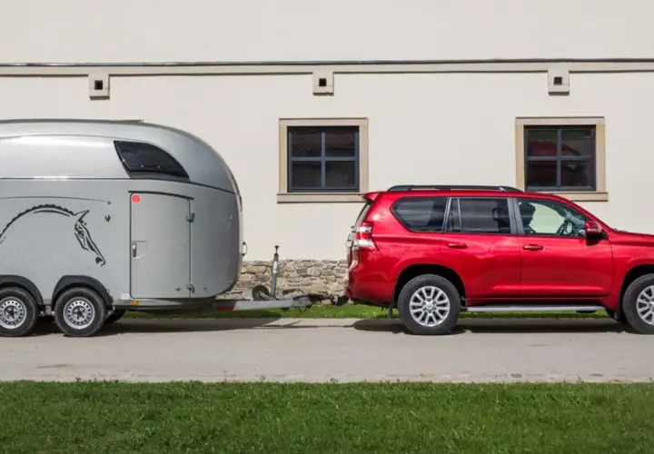 Czerwony SUV holuje przyczepę z koniem. B+E co daje? Możliwość przewiezienia ukochanego zwierzęcia na zawody.