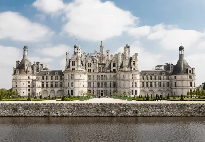 Majestatyczny zamek Chambord, perła krajobrazu Loary, wznosi się nad spokojną wodą.