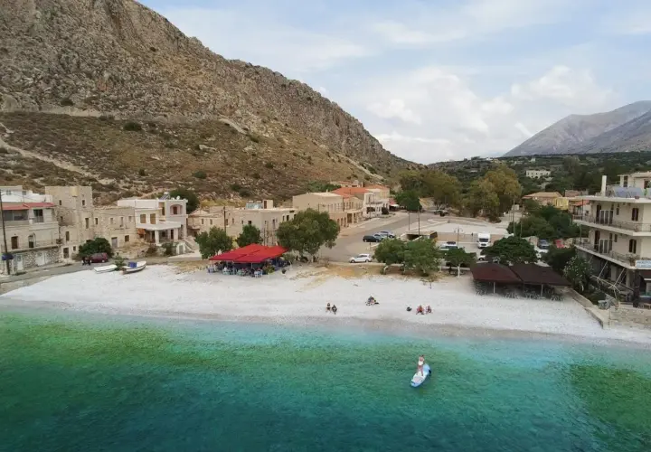 Malownicza zatoka z kamienistą plażą, domkami i tawerną. Idealne miejsce na wakacje kamperem w Grecji.