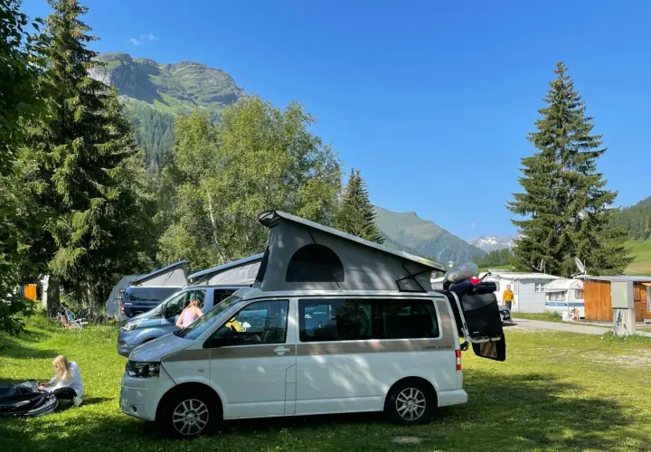 Kampery na kempingu w Austrii. W tle góry i lasy. Przepisy drogowe Austria są ważne dla bezpiecznej podróży.