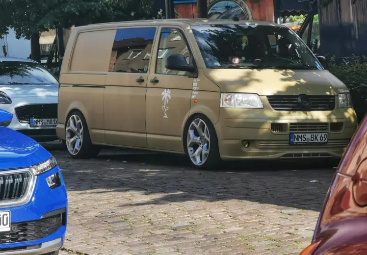 Złoty bus, przerobiony na kampera, z naklejką palmy. Czekam na przepisy, by ruszyć w podróż!