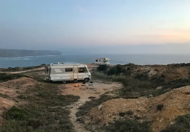 Dwa kampery na klifie nad oceanem. Ognisko i krzesła czekają na wieczór. To nie jest parkowanie w Berlinie, ale idealne miejsce na nocleg.