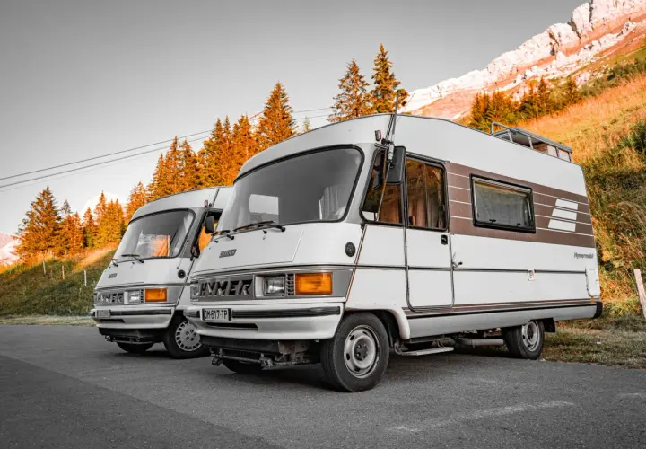 Dwa kampery Hymer stoją na tle gór i jesiennych drzew. Pamiętaj o opłatach drogowych Austria powyżej 3,5 tony.