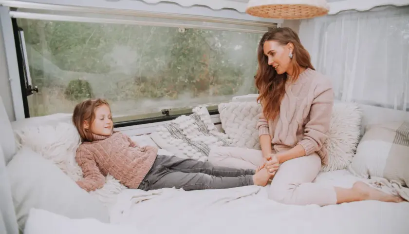Mama i córka odpoczywają w przytulnym kamperze. Czy w kamperze można spać podczas jazdy? To pytanie zadaje sobie wielu podróżujących.