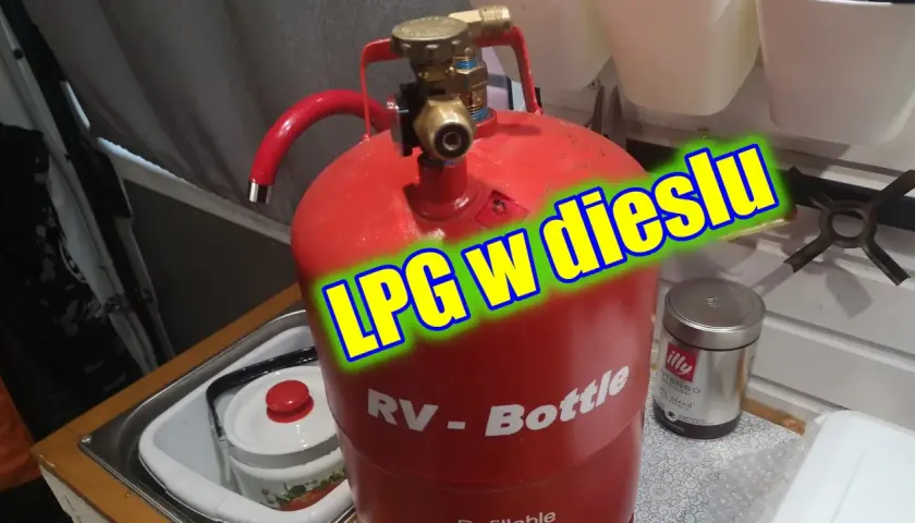 Czerwona butla gazowa RV-Bottle z zaworem, gotowa do tankowania LPG w dieslu. Obok puszka kawy Illy.
