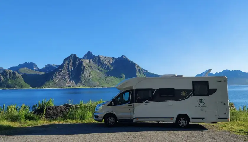 Kamper na tle gór i jeziora, idealne miejsce na wakacje w Norwegii latem.