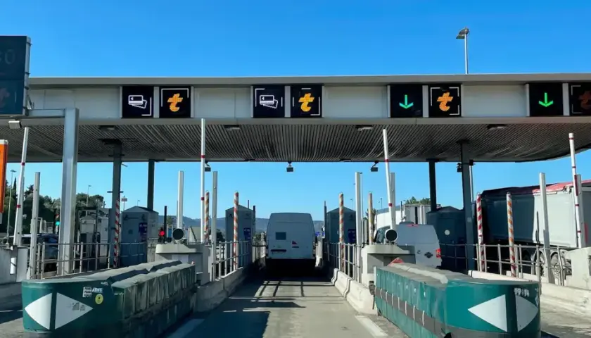 Francuskie winiety na autostradzie. Znaki informują o pasach do płatności, ograniczeniu prędkości do 30 km/h i kierunku jazdy.