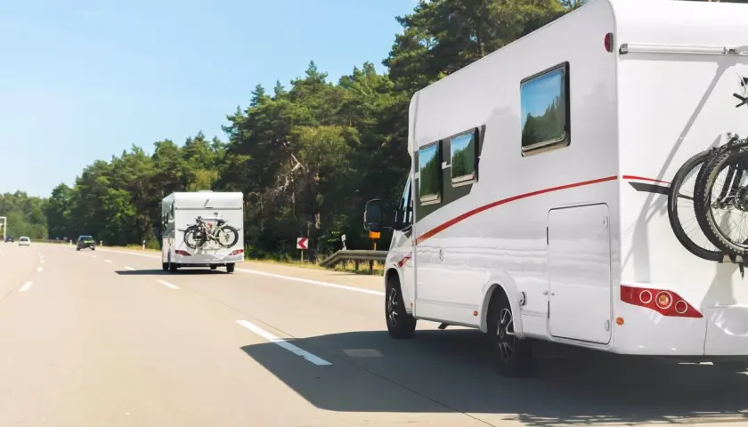 Dwa kampery jadą autostradą w Polsce. Na jednym z nich zamontowany jest bagażnik na rowery.