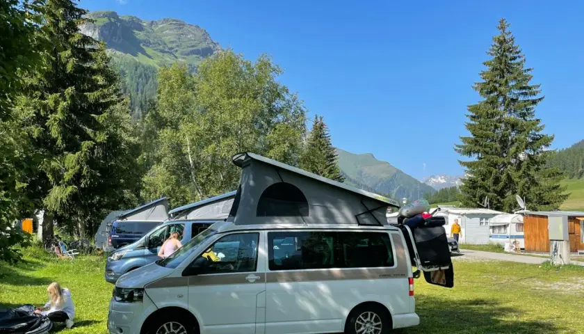 Kampery na kempingu w Austrii. W tle góry i lasy. Przepisy drogowe Austria są ważne dla bezpiecznej podróży.