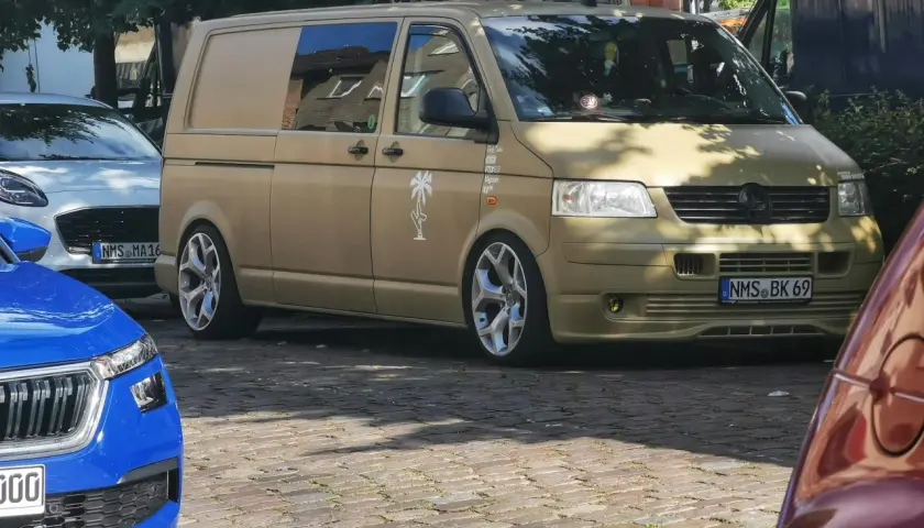 Złoty bus, przerobiony na kampera, z naklejką palmy. Czekam na przepisy, by ruszyć w podróż!