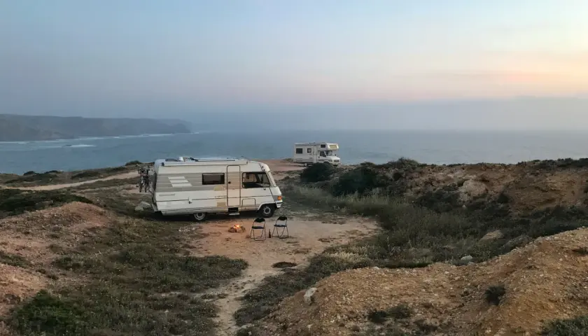 Dwa kampery na klifie nad oceanem. Ognisko i krzesła czekają na wieczór. To nie jest parkowanie w Berlinie, ale idealne miejsce na nocleg.