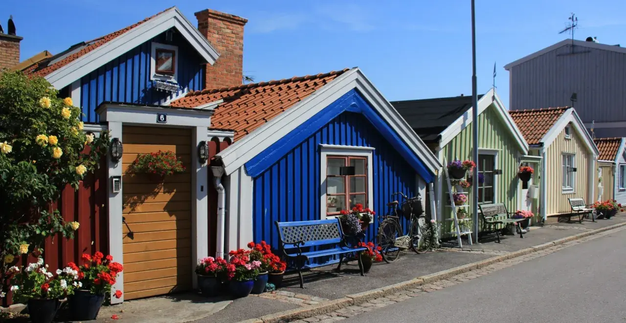 Kolorowe domki w Karlskronie, idealne na spacer i zwiedzanie. Wiele kwiatów i rowerów dodaje uroku.