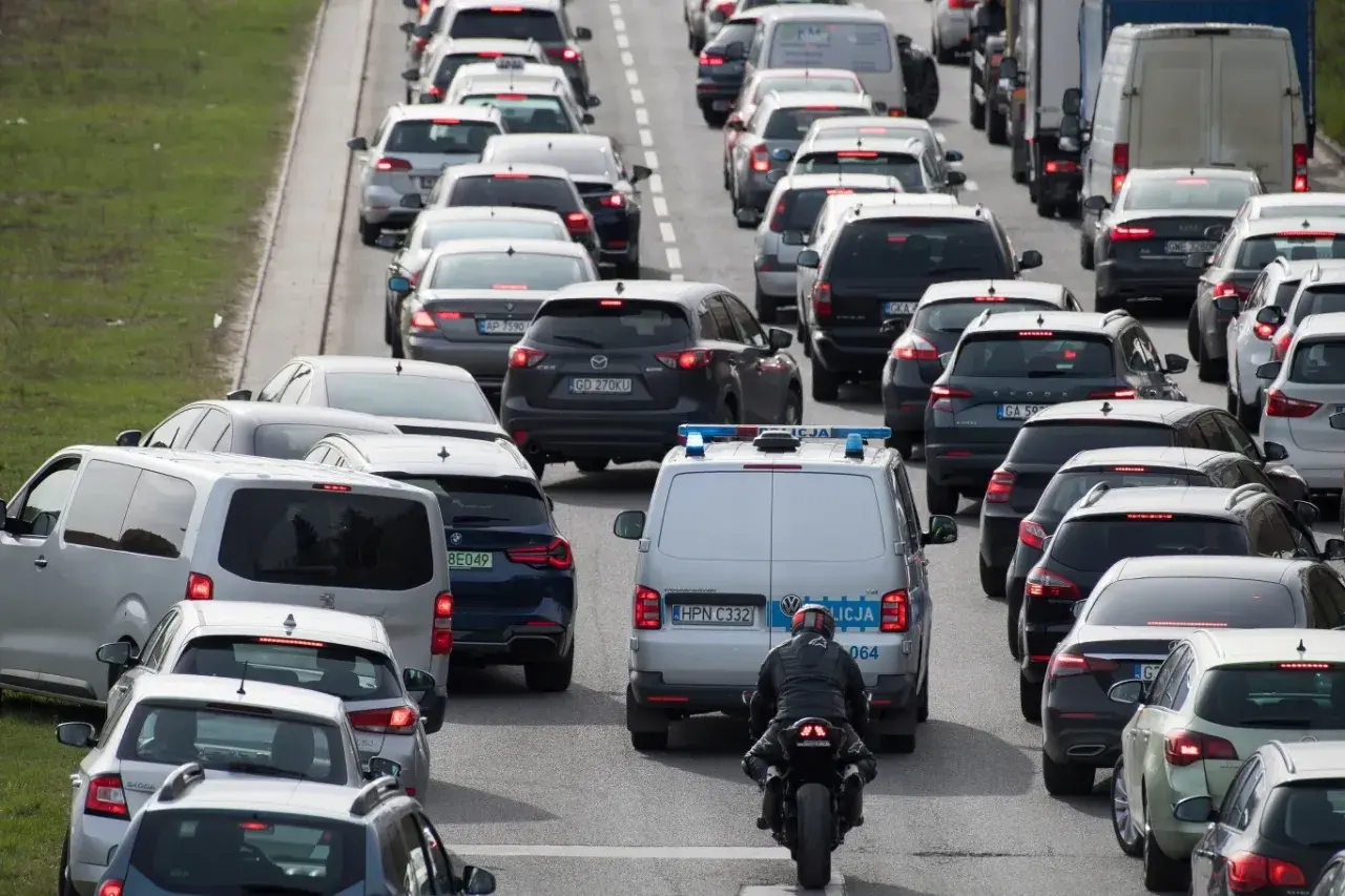 Korki na drodze ekspresowej. Policja pilnuje porządku, czy można cofać na drodze ekspresowej? Kierowcy stoją w długim sznurze aut.