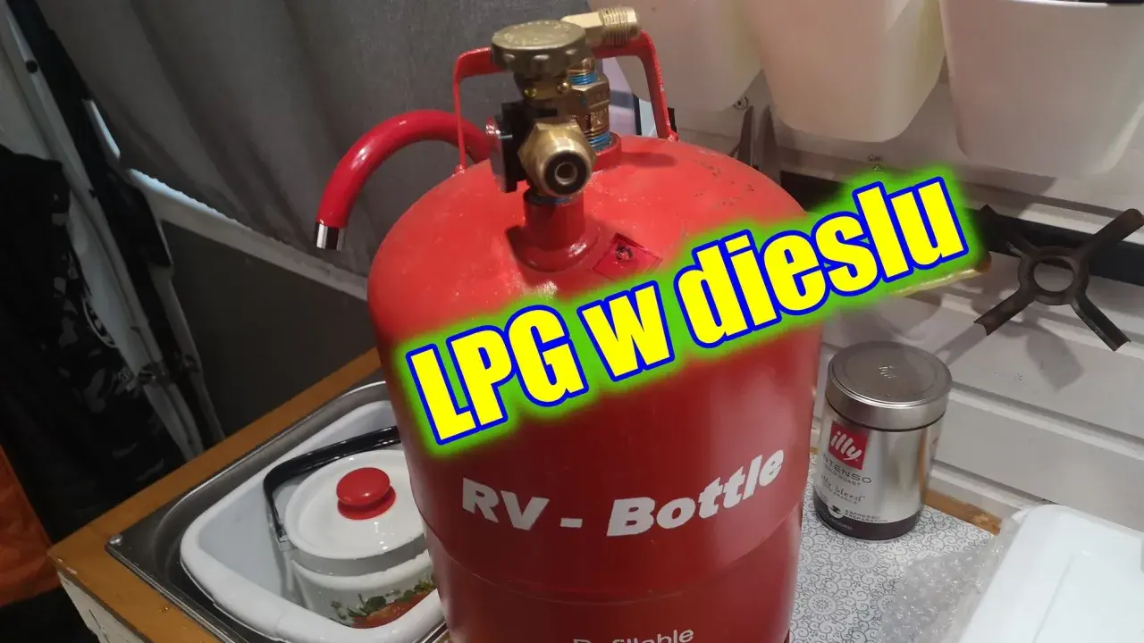 Czerwona butla gazowa RV-Bottle z zaworem, gotowa do tankowania LPG w dieslu. Obok puszka kawy Illy.