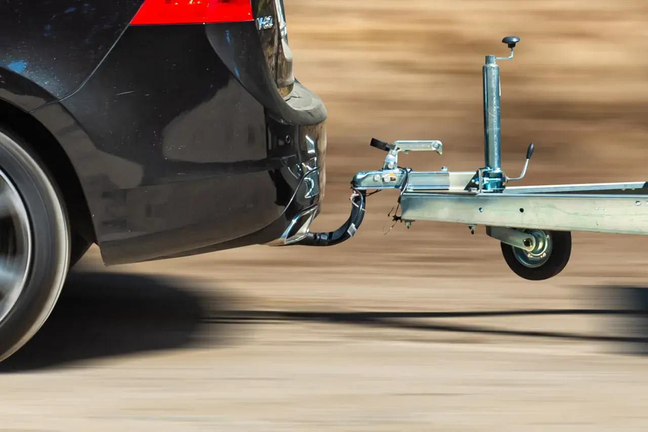 Samochód holuje przyczepę kempingową. Prawidłowe poziomowanie przyczepy kempingowej jest kluczowe dla bezpieczeństwa jazdy.