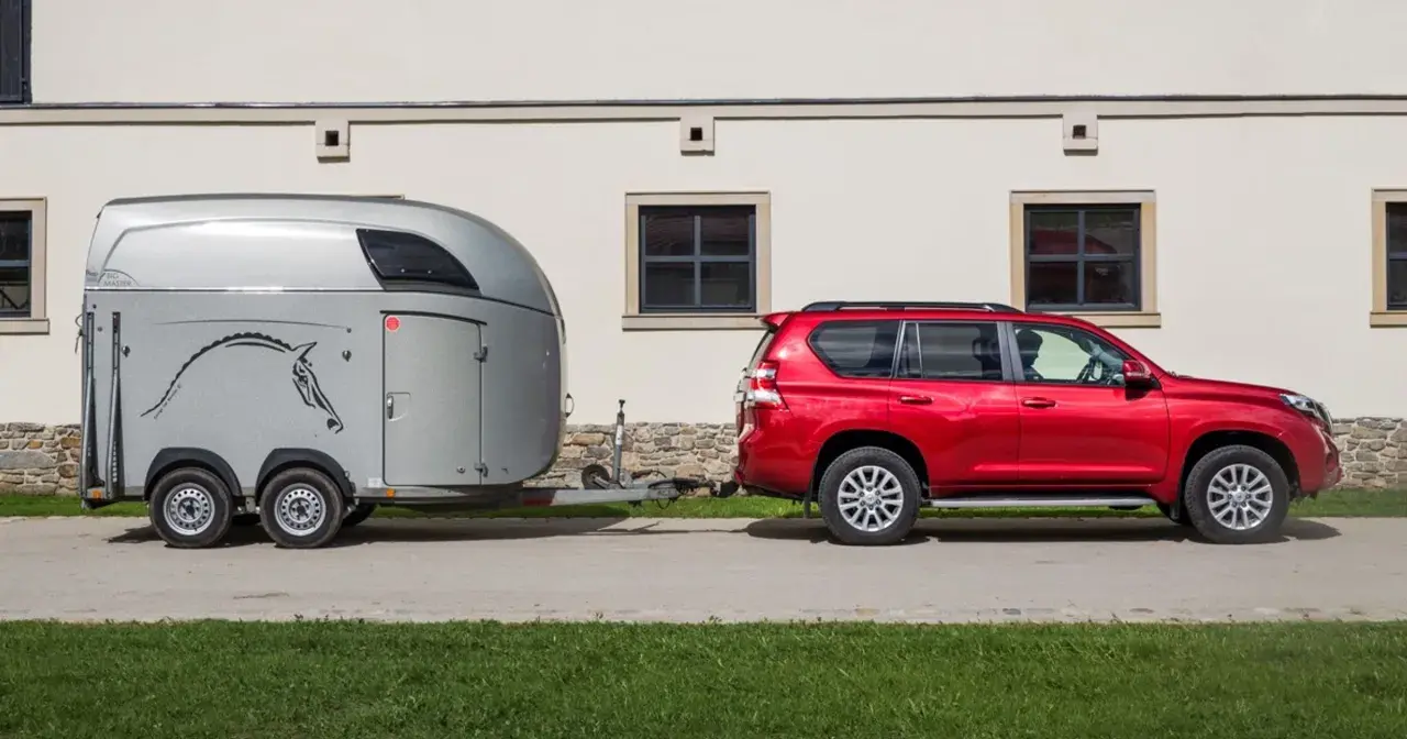 Czerwony SUV holuje przyczepę z koniem. B+E co daje? Możliwość przewiezienia ukochanego zwierzęcia na zawody.