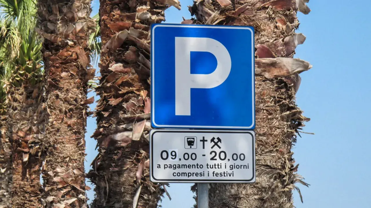 Znaki drogowe we Włoszech: niebieski znak "P" z informacją o płatnym parkingu od 9:00 do 20:00, codziennie, w tym święta.
