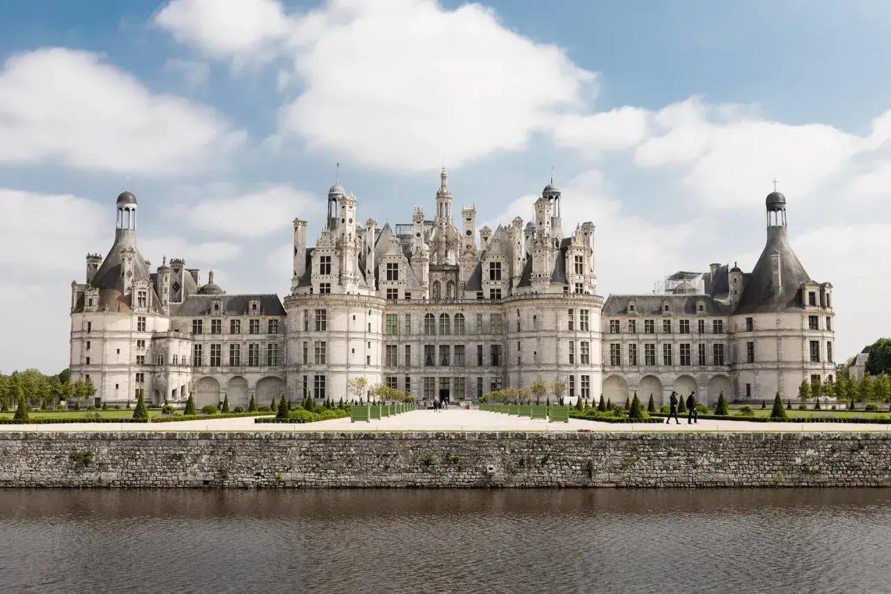 Majestatyczny zamek Chambord, perła krajobrazu Loary, wznosi się nad spokojną wodą.