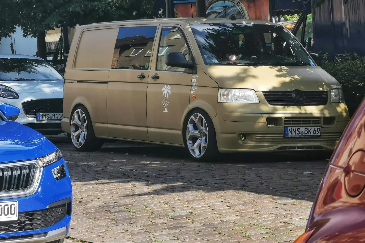 Złoty bus, przerobiony na kampera, z naklejką palmy. Czekam na przepisy, by ruszyć w podróż!