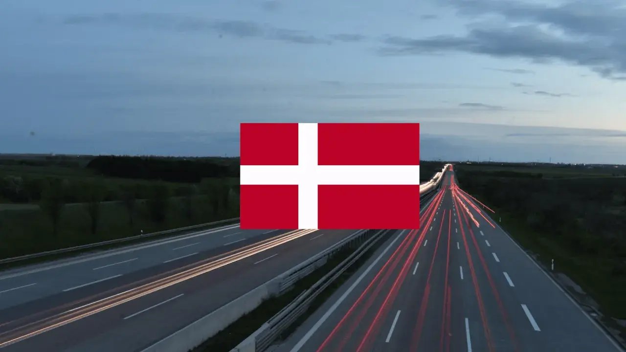 Autostrada nocą z widocznymi smugami świateł samochodów i flagą Danii. Winieta Danii na tle krajobrazu.