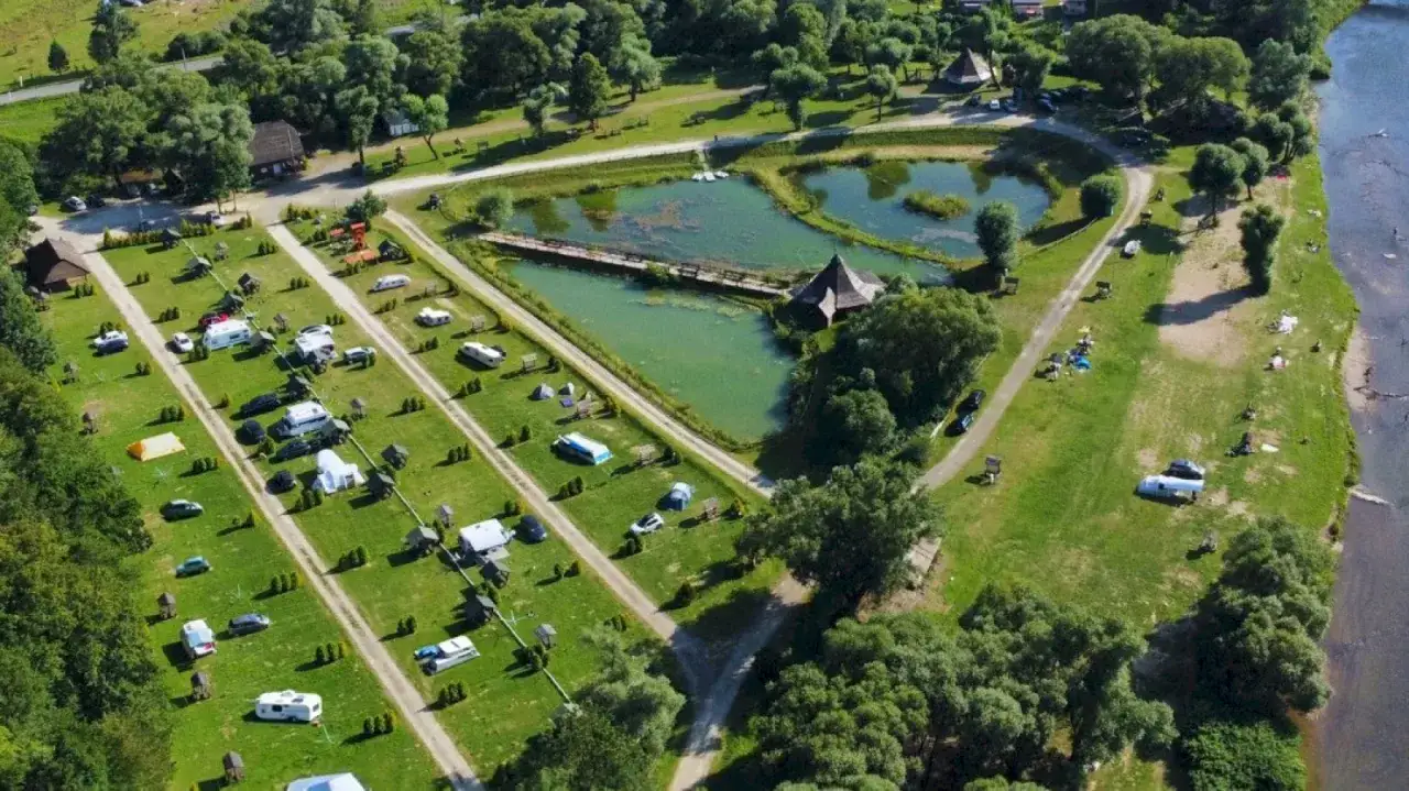 Widok z lotu ptaka na diabla g&oacute;ra camping z namiotami, kamperami i jeziorkiem.