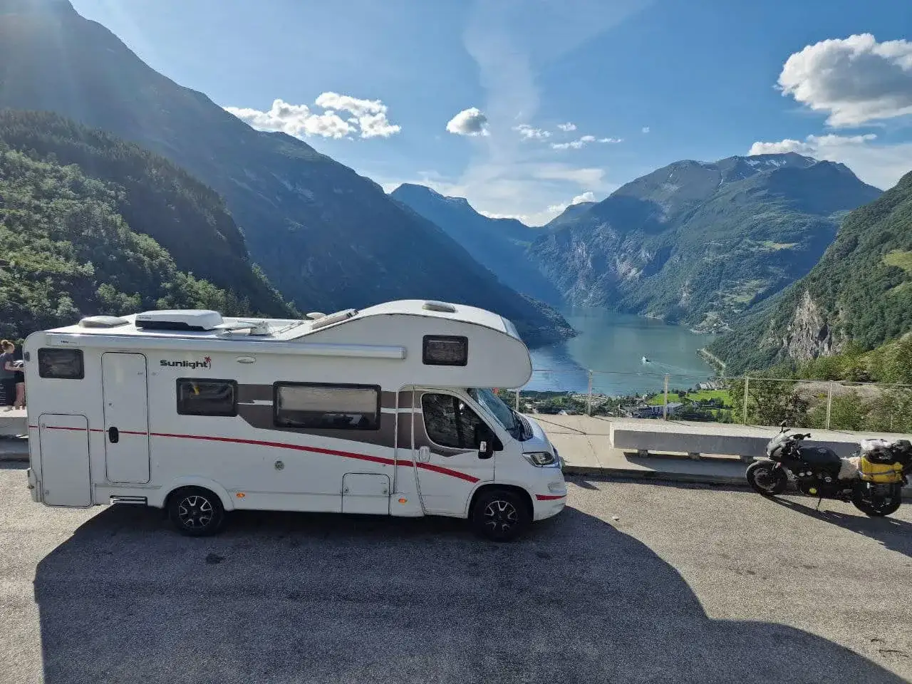 Kamper w malowniczej Norwegii, z widokiem na fiord. Podr&oacute;żując po tym kraju, warto pamiętać o norwegia opłaty drogowe.