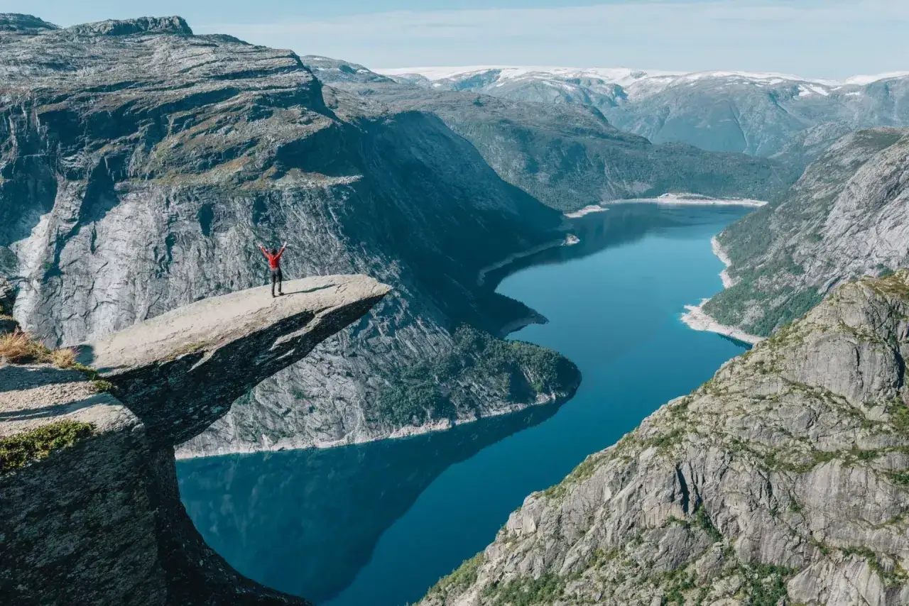 Osoba na Trolltundze, spektakularnym skalnym występie. To idealne miejsce w Norwegii, gdzie warto pojechać dla zapierających dech w piersiach widoków.